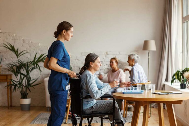 Two older adults in a cozy living room using a tablet together, one showing the other how to use a video call app.
